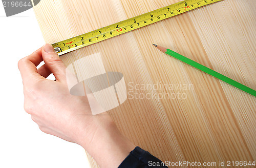 Image of Using a steel tape measure on a wooden board 