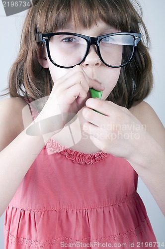 Image of girl with herd sunglasses blowing a balloon