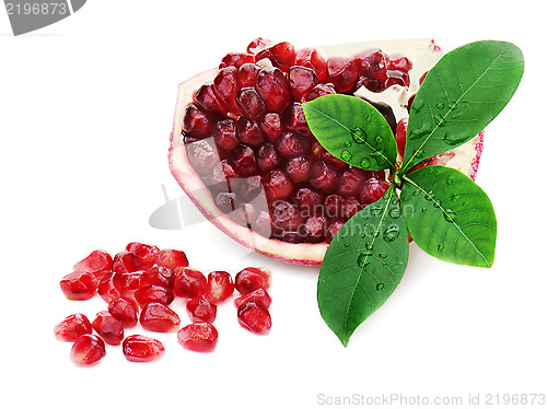 Image of Part of pomegranate fruit with green leaves isolated on white ba