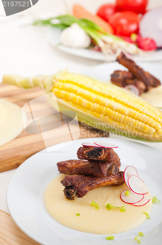 Image of pork ribbs on polenta corn cream bed