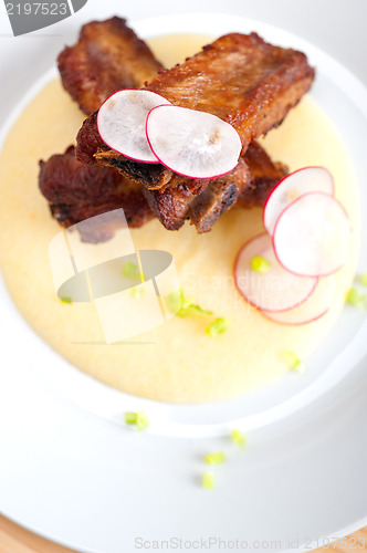 Image of pork ribbs on polenta corn cream bed