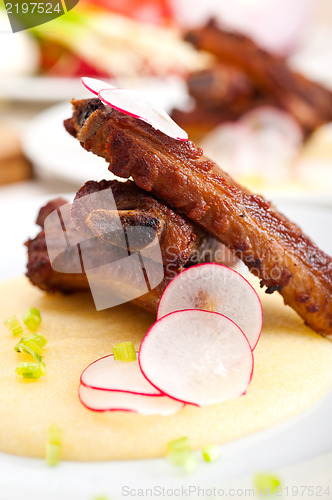 Image of pork ribbs on polenta corn cream bed