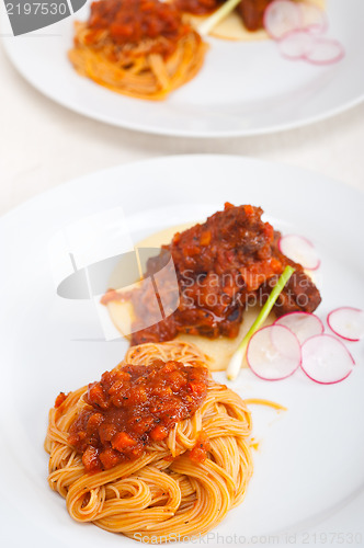 Image of pasta with pork ribbs sauce on polenta bed