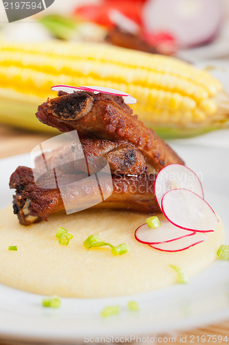 Image of pork ribbs on polenta corn cream bed