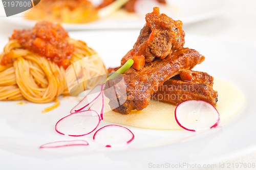 Image of pasta with pork ribbs sauce on polenta bed