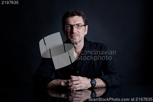 Image of attractive adult man with glasses on black background