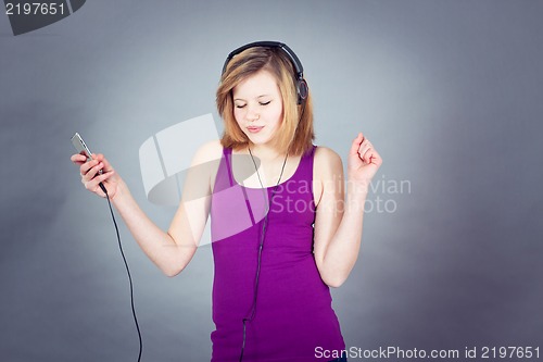 Image of dancing happy teenager girl listening to music 
