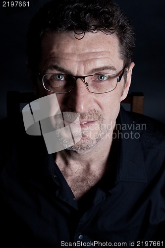 Image of attractive adult man with glasses on black background