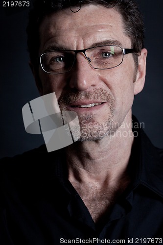 Image of attractive adult man with glasses on black background