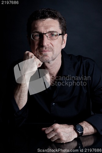 Image of attractive adult man with glasses on black background