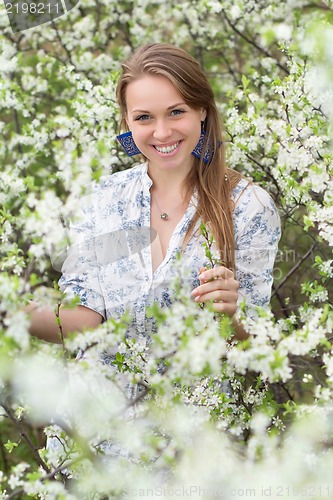 Image of Smiling blonde in blooming garden