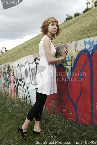 Image of Attractive young woman against a wall of graffiti