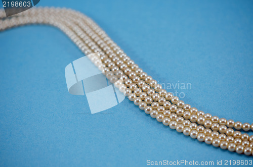 Image of pearl necklace collar bead closeup blue background 