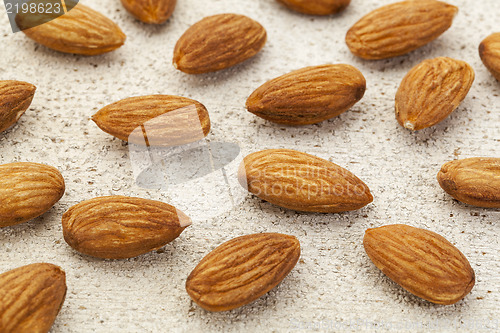 Image of raw almonds on white wood