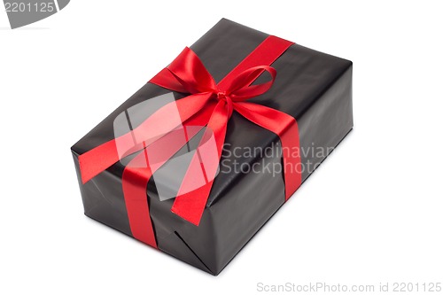 Image of Black gift box with red satin ribbon and bow, over white background.