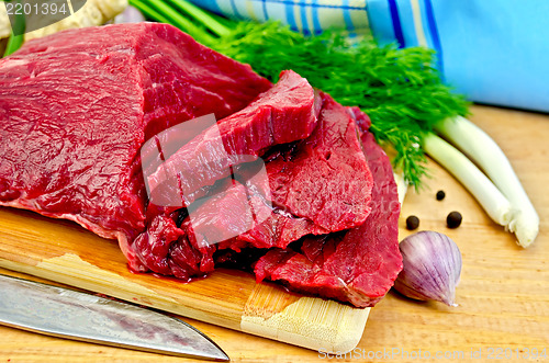 Image of Meat beef on a wooden board with a knife