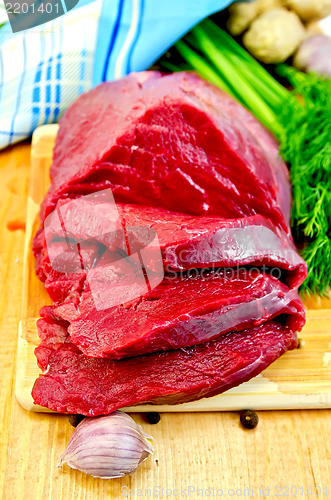 Image of Meat beef on a wooden board with garlic