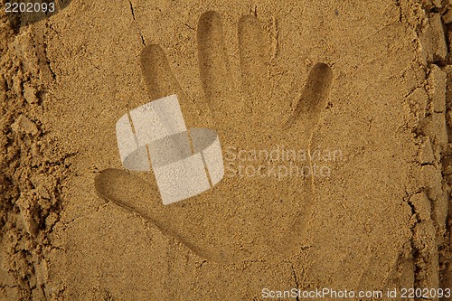 Image of hand print in the sand 