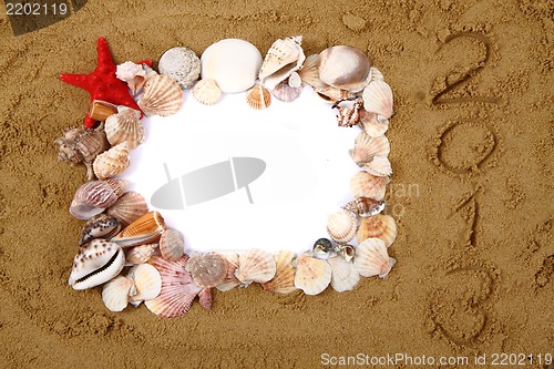 Image of sea shells, paper and yellow sand