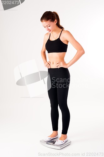 Image of happy young woman on weight scales