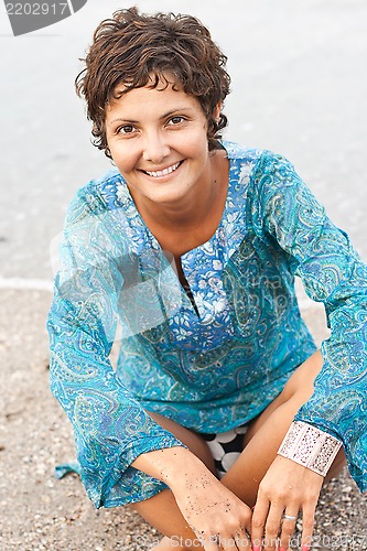 Image of brunet woman in blue dress on the beach