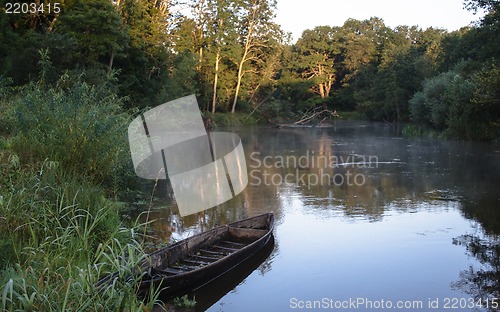 Image of Beautiful river and old rowing boat in green grass