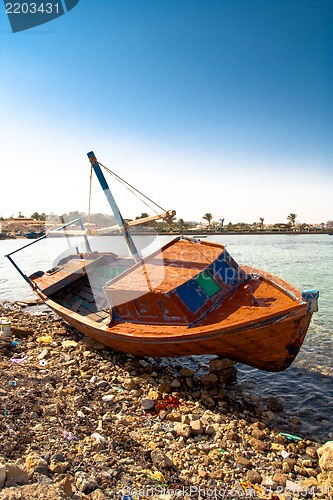 Image of Red rowboat lying at shore