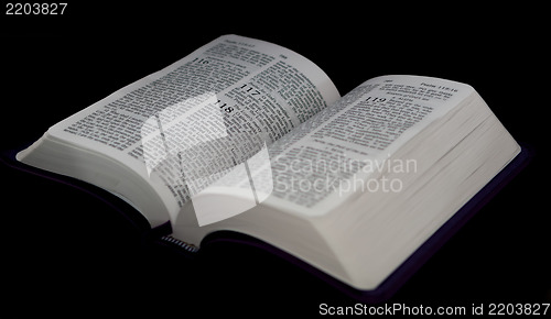 Image of open Bible to psalm 118 isolated on a black background.