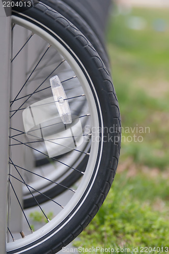 Image of tires with reflector of parked bikes in a city