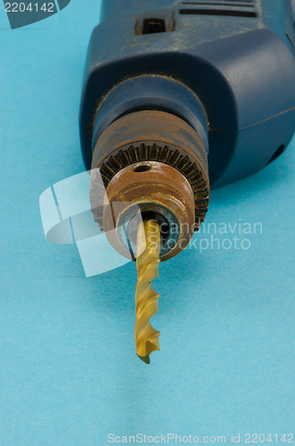 Image of old electric drill golden bit closeup 