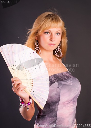 Image of Beautiful young woman with fan