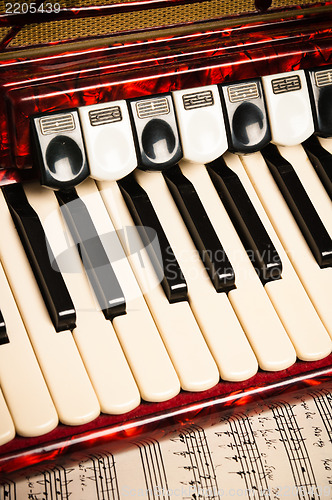 Image of Red accordion and sheet music, close up