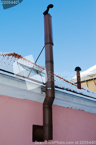 Image of Metal chimney at a wall of a building