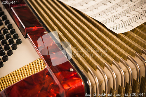 Image of Red accordion and sheet music, close up