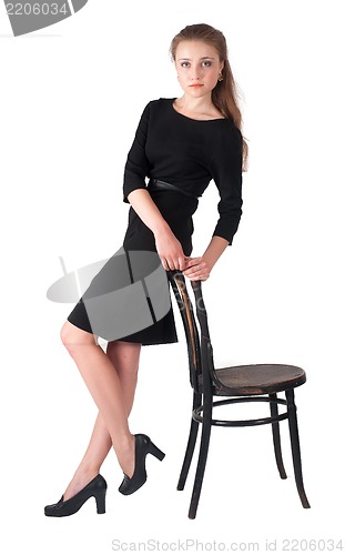 Image of Attractive brunette woman holding on chair