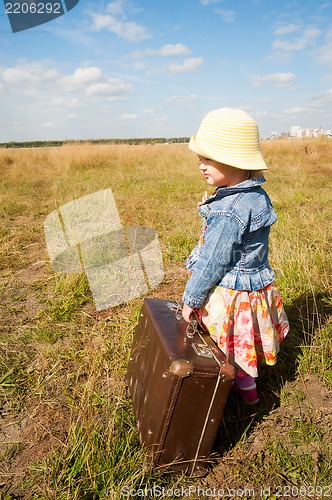 Image of lonely girl with suitcase. Back view