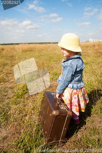 Image of lonely girl with suitcase. Back view