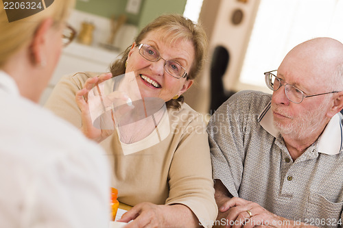 Image of Doctor or Nurse Explaining Prescription Medicine to Senior Coupl