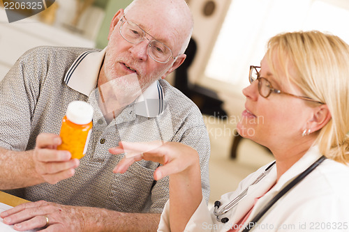 Image of Doctor or Nurse Explaining Prescription Medicine to Senior Man