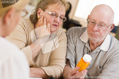 Image of Doctor or Nurse Explaining Prescription Medicine to Senior Coupl