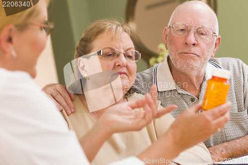 Image of Doctor or Nurse Explaining Prescription Medicine to Senior Coupl