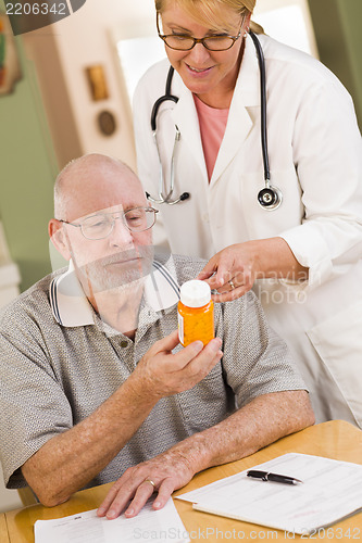 Image of Doctor or Nurse Explaining Prescription Medicine to Senior Man