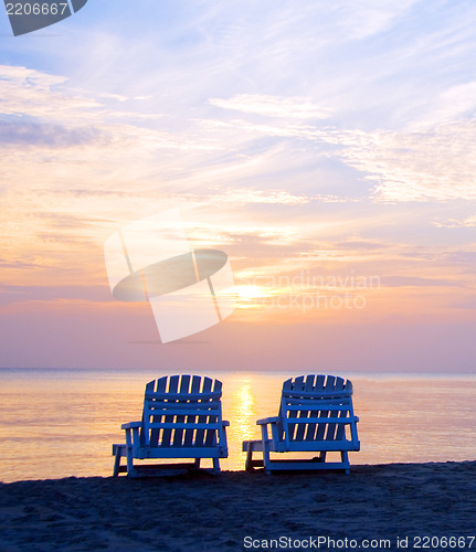 Image of sunset on Picnic Center beach  lounge chairs and boats in distan