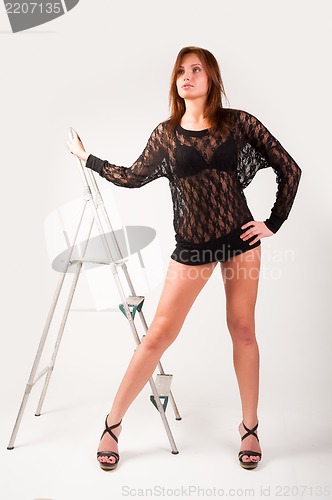 Image of Pretty brunette girl standing at ladder