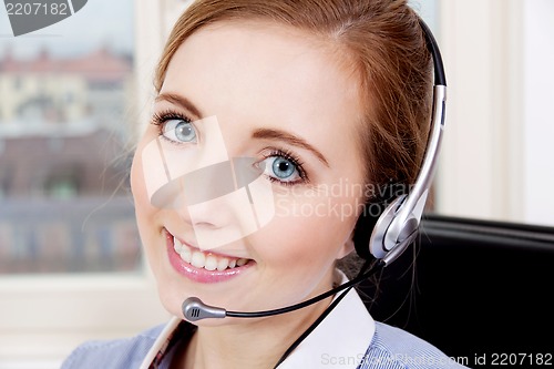 Image of smiling young female callcenter agent with headset