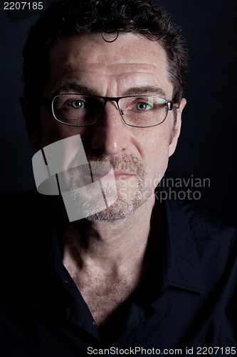 Image of attractive adult man with glasses on black background