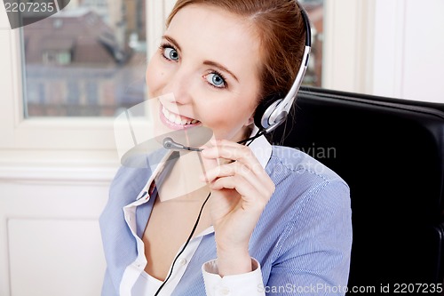 Image of smiling young female callcenter agent with headset