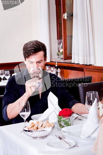 Image of couple drinking red wine in restaurant