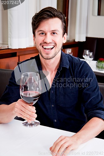 Image of couple drinking red wine in restaurant