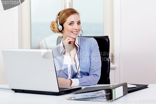 Image of smiling young female callcenter agent with headset